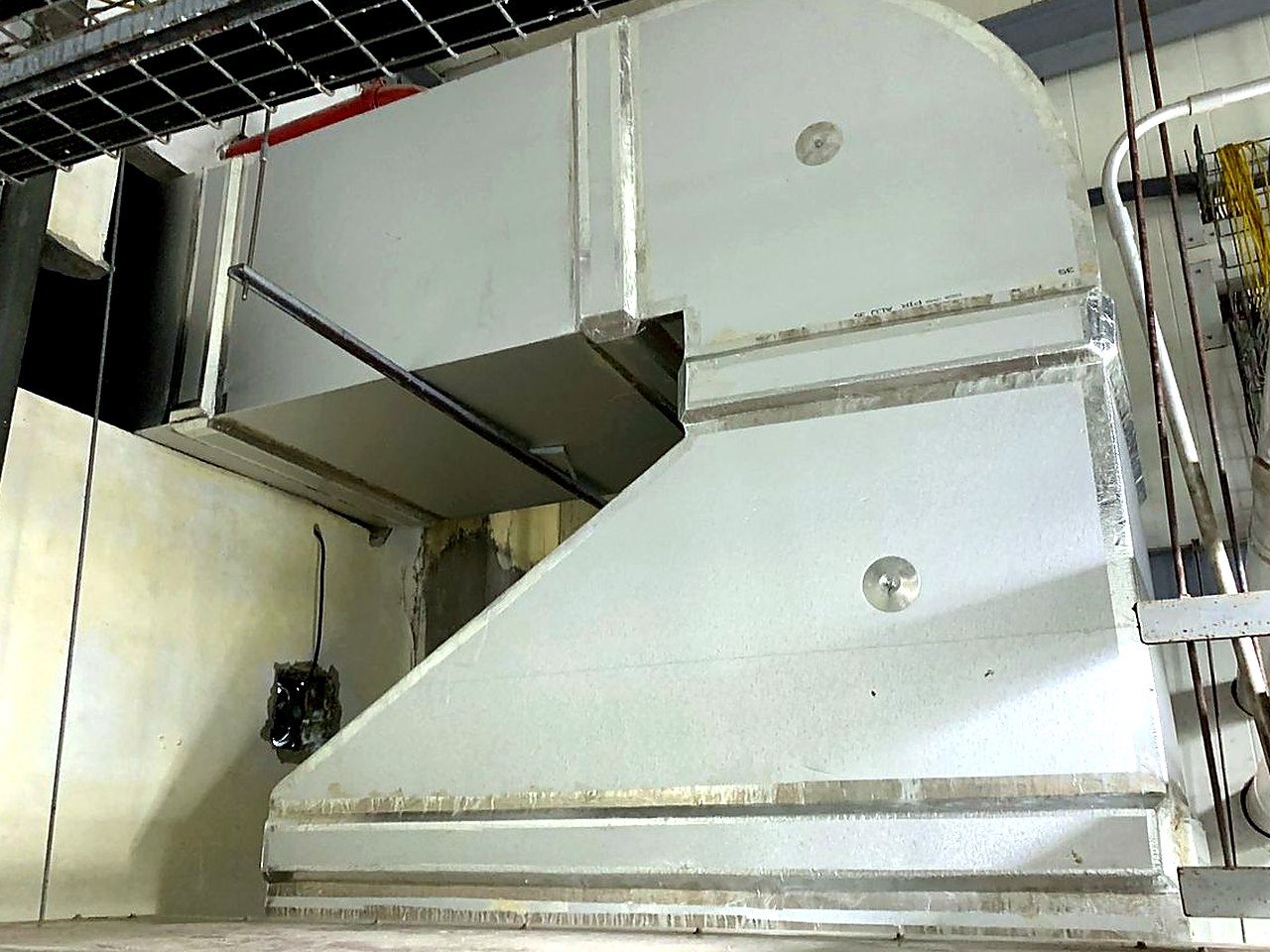 Ductería metálica conectada a un equipo de climatización en una nave industrial